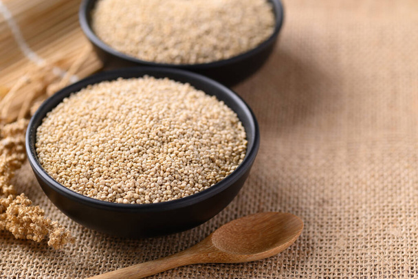 Sementes de quinoa marrom em uma tigela com colher, sementes comestíveis são de alta proteína, comida saudável - Foto, Imagem