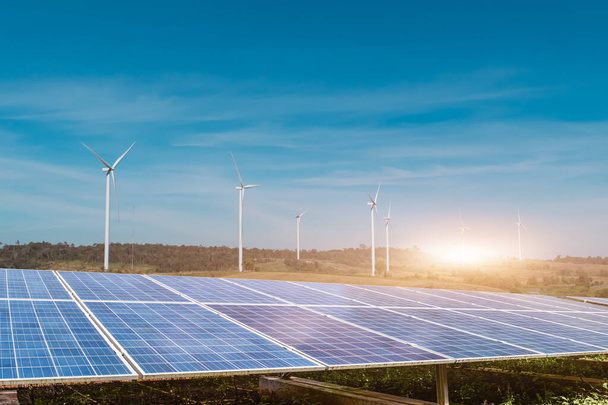 Sonnenkollektoren mit Windrädern vor blauem Himmel. Photovoltaik, alternative Stromquelle. Nachhaltiges Ressourcenkonzept. - Foto, Bild