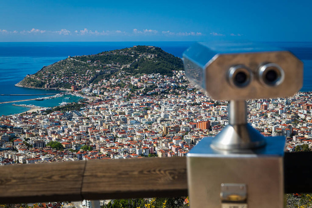 panoramisch uitzicht van de berg naar het resort stad met een heuvel en zee kust Coin Operated Binocular viewer next to the waterside promenade in Antalya met uitzicht op de baai en de stad.  - Foto, afbeelding