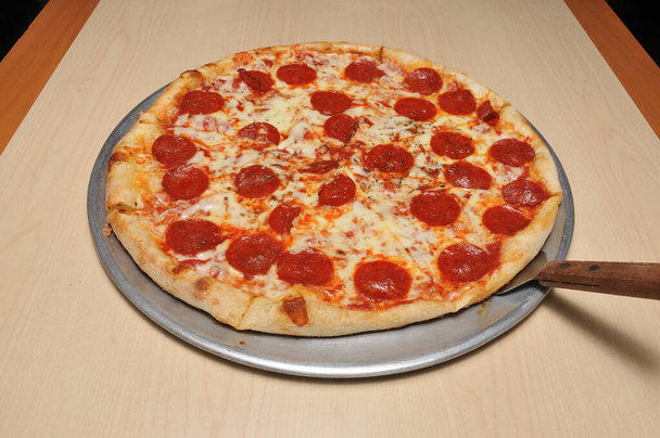 Heerlijke tomatensaus kaas bedekt met hete en smakelijke pepperoni pizza taart  - Foto, afbeelding