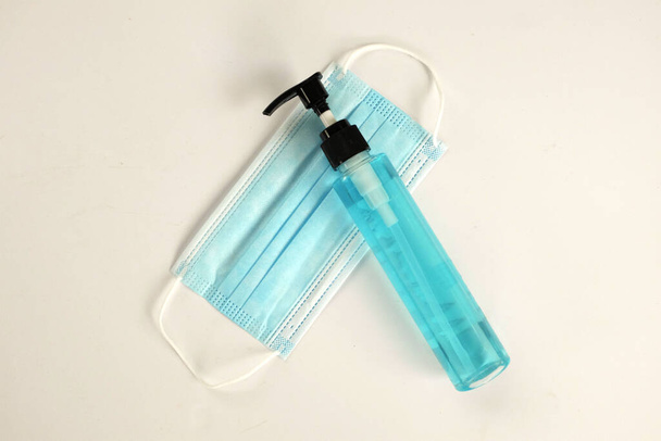 Hand sanitizer spray and surgical facial mask as protection coronavirus on white background - Photo, Image