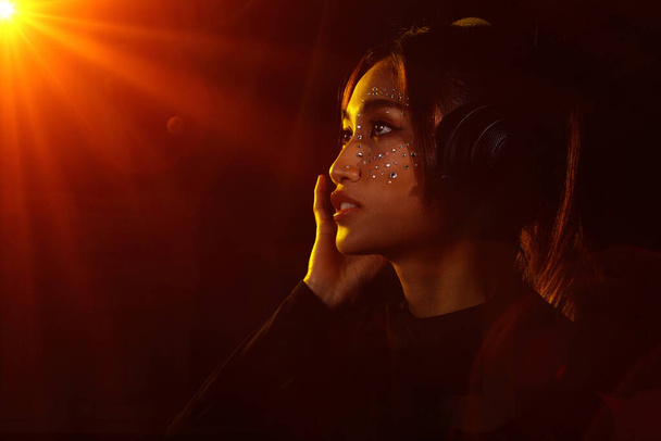 Mujer asiática poner auriculares orejeras cantar una canción en voz alta poder sonido sobre colgante micrófono condensador. - Foto, Imagen