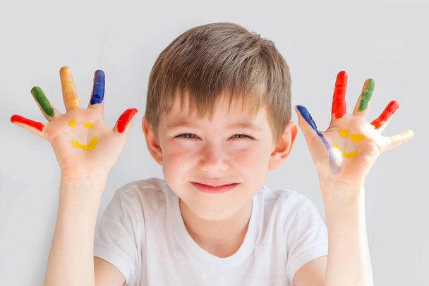 Portrait of joyful cute preschooler little boy 5-6 years with colorful painted hands. Smiley hands. Finger drawing, education and child development. Happy childhood - Foto, Imagem