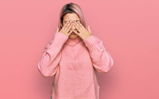 Spaanse vrouw met roze haar dragen casual winter trui wrijven ogen voor vermoeidheid en hoofdpijn, slaperige en vermoeide uitdrukking. gezichtsproblemen  - Foto, afbeelding