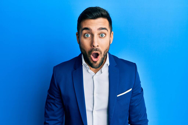 Young hispanic businessman wearing business jacket afraid and shocked with surprise expression, fear and excited face.  - Photo, Image