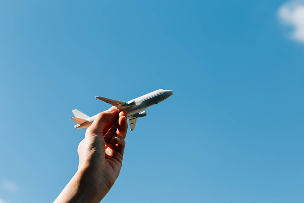 Model letadla v ruce na slunné obloze. Pojmy cestování, doprava - Fotografie, Obrázek