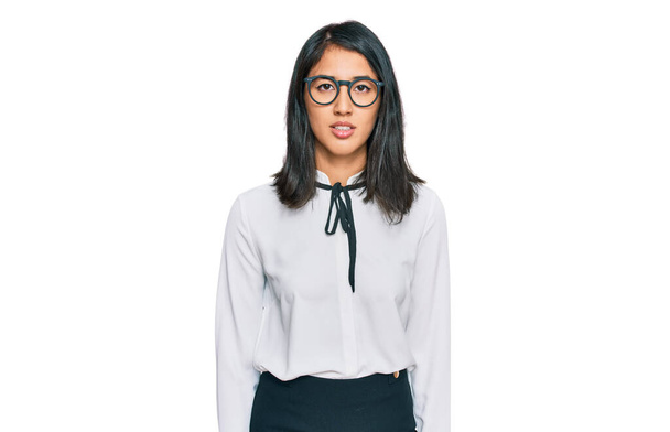 Beautiful asian young woman wearing business shirt and glasses with serious expression on face. simple and natural looking at the camera.  - Foto, immagini