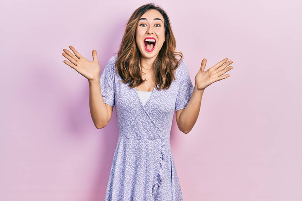 Nuori latino tyttö yllään rento vaatteita juhlii hullu ja hämmästynyt menestystä kädet esille ja avoimet silmät huutaa innoissaan. voittajan käsite  - Valokuva, kuva