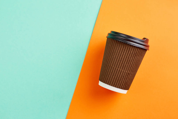 Tasse à café en papier sur fond orange et turquoise. Gros plan blanc tasse de café en papier artisanal. Place pour le texte. - Photo, image