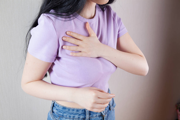 girl presses her hands on her chest chest pain - Foto, imagen