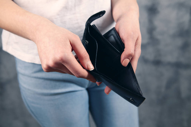 girl holds an empty wallet in his hands. - Foto, Bild