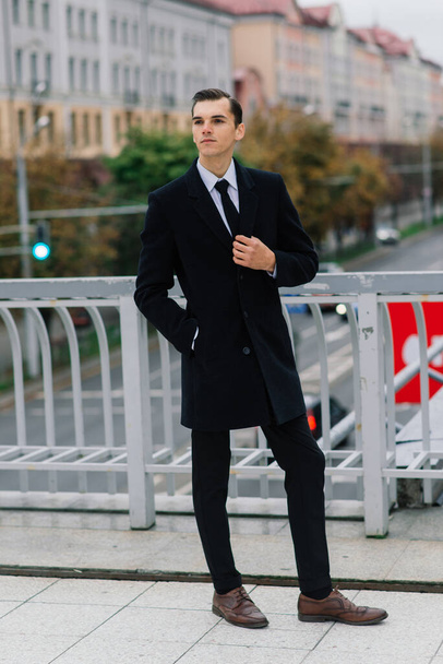 Ένας άντρας με κομψό κοστούμι. Επιχειρηματίας σε μια φθινοπωρινή πόλη - Φωτογραφία, εικόνα