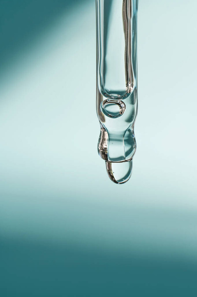 A drop of cosmetic oil falls from the pipette - Fotografie, Obrázek