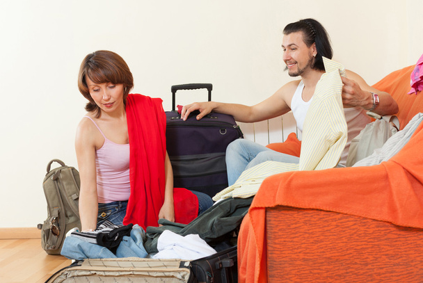 Couple packing a suitcase at home - Fotó, kép