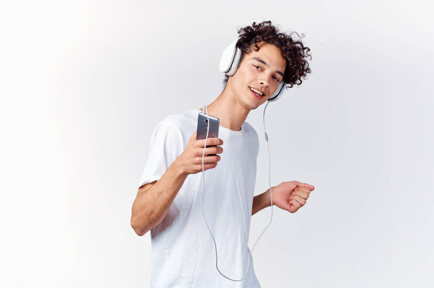 emotionaalinen mies valkoisessa t-paidassa kuuntelemassa musiikkia kuulokkeilla rajattu näkymä - Valokuva, kuva