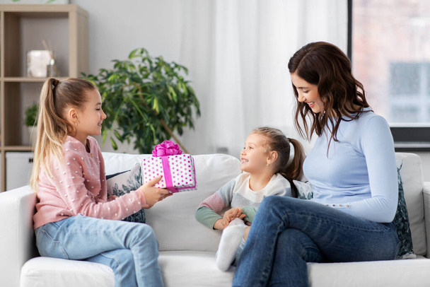 girl giving present to younger sister at home - Foto, Bild
