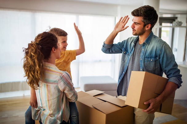 Happy family unpacking boxes in new home on moving day. People, real estate, new home concept - 写真・画像