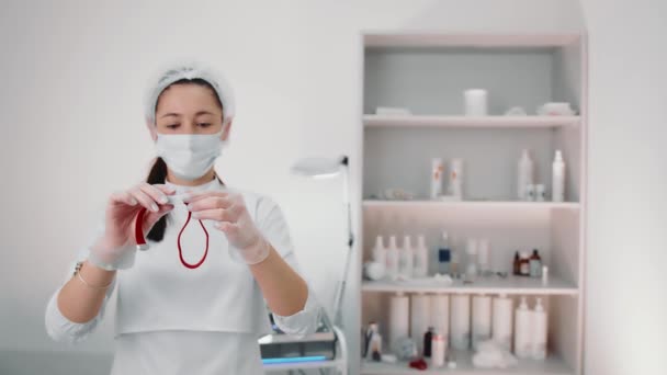 Una enfermera sosteniendo un torniquete antes de sacar sangre. Muestreo de sangre en el laboratorio - Metraje, vídeo