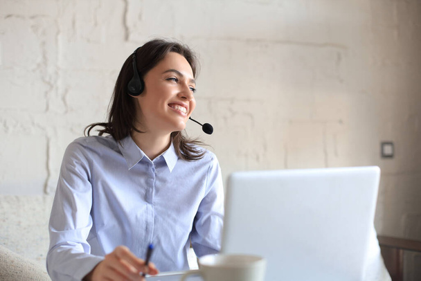 Freelance operator talking with headsets and consulting clients from home office. - Φωτογραφία, εικόνα