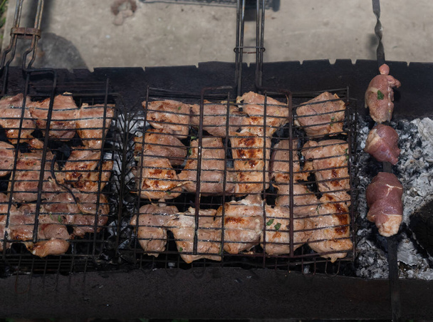 pieces of meat in a mesh on a grill. - Photo, Image