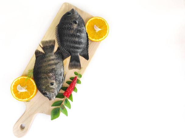 parelmoer vis / Karimeen versierd met kruiden en fruit. geïsoleerd op witte achtergrond.Ruimte voor tekst, Selectieve focus. - Foto, afbeelding