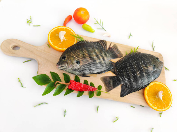 parelmoer vis / Karimeen versierd met kruiden en fruit. geïsoleerd op witte achtergrond.Selectieve focus. - Foto, afbeelding