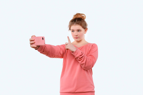 Видеосвязь через смартфон. Молодая девушка использует телефон для видеозвонка, онлайн-встречи. Она разговаривает со своими друзьями - Фото, изображение