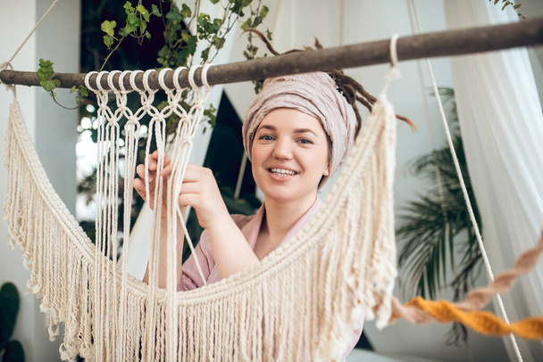 Young woman spending time at home busy with her macrame - 写真・画像