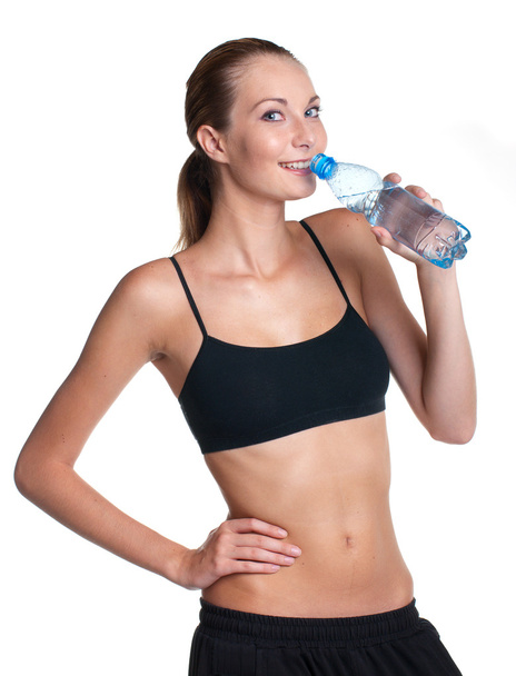 Woman in fitness pose holding water bottle - Фото, изображение