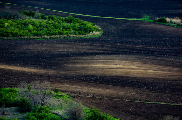 Текстура коричневой сельскохозяйственной почвы. Прекрасный рассвет на ферме. Ферма в Молдове, Европе. Свежевспаханное весеннее поле для посадки семян овощей. - Фото, изображение