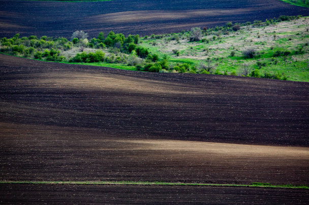 Textura de suelo agrícola marrón. Hermoso amanecer en la granja. La granja en Moldavia, Europa. Campo de primavera recién arado para plantar semillas vegetales. - Foto, imagen