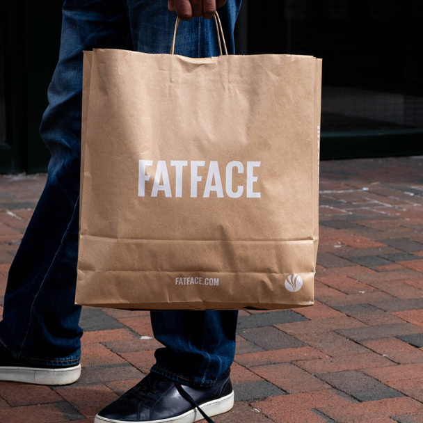 Epsom Surrey London UK, May 02 2021, Man Holding A Brown Paper Fatface Carrier Bag - Фото, изображение