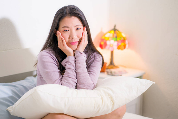 lifestyle portrait of young and beautiful Asian woman at home -  attractive and happy Japanese girl looking relaxed and cheerful on bed  - Foto, immagini