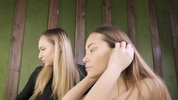 attraente dai capelli lunghi biondo caucasico compongono artista e cliente nel salone di bellezza - Filmati, video