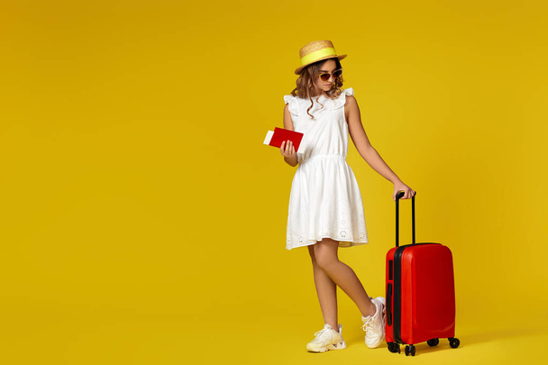 teenager girl in hat and sunglasses with red suitcase - Fotó, kép