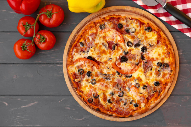Delicious pizza on gray wooden background top view - Foto, Imagen