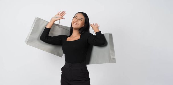Love Shopping concept. Beautiful Asian woman carrying gray color bags shopping online. isolated on white studio background. online shopping bag. black hair woman love shopping online. Online purchase - Photo, image