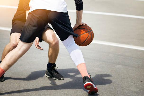 Young guys are playing street basketball. Healthy lifestyle concept. - Foto, imagen