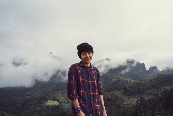 Hombre joven asiático en camisa escocesa y sombrero negro senderismo en la cima de la montaña por encima de las nubes y la niebla Hiker al aire libre. Doi Luang Chiang Dao Chiangmai Provincia, Por la mañana. - Foto, Imagen