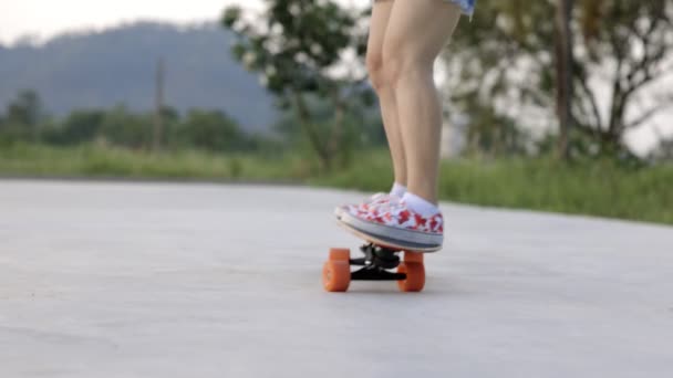 Atraktivní asijské žena s bezpečností skateboarding koleno pad bruslení na skateboard park. Žena těšit léto aktivní životní styl hrát extrémní sportovní surfování brusle ve veřejném parku. - Záběry, video