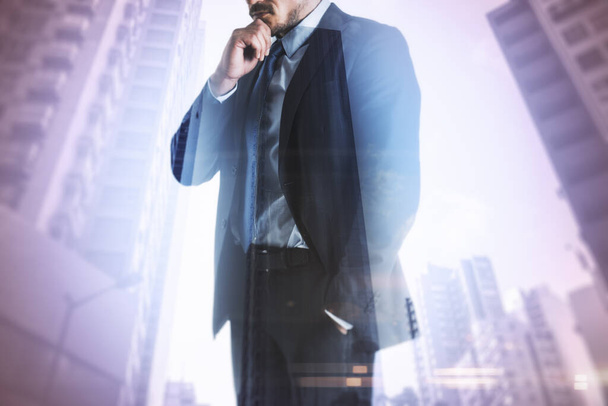 Businessman standing thinking with skyscrapers in the background, decision and entrepreneurship concept, double exposure - Foto, Imagem