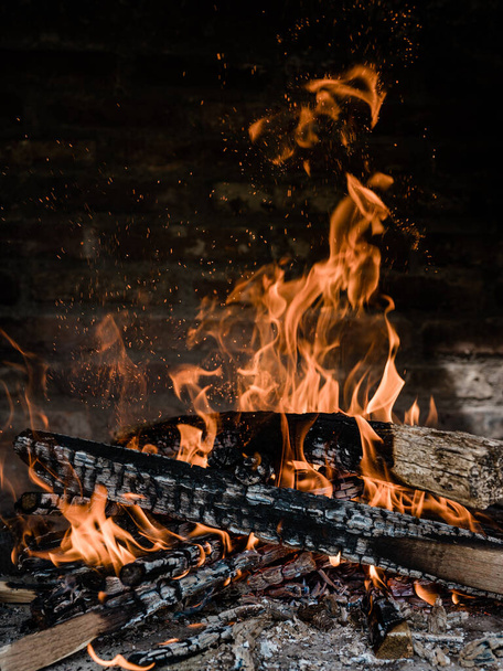 Огонь горит в камине для приготовления барбекю. Горящее дерево на камине построено из кирпича. - Фото, изображение