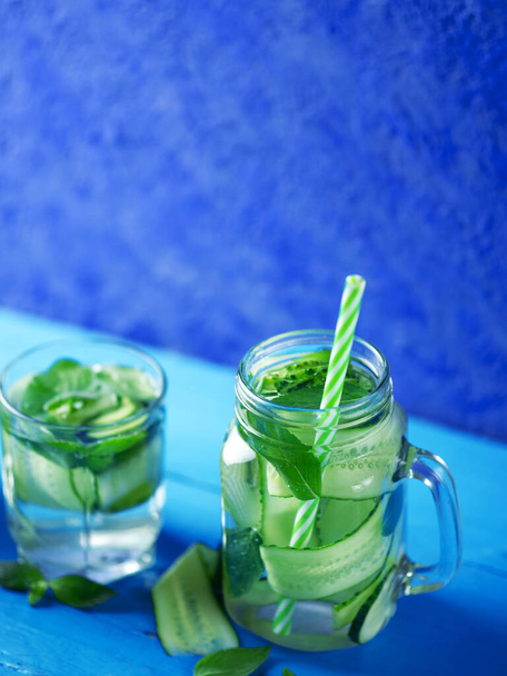 Gurkenwasser mit Minze auf blauem Hintergrund - Foto, Bild