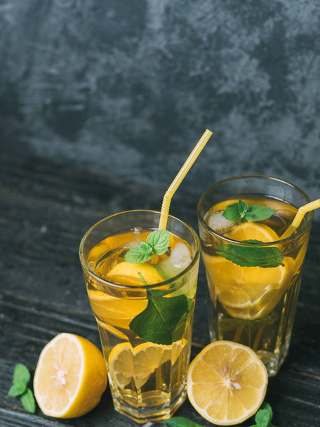 Két pohár Mojito vagy limonádé egy sötét asztalon. Citromos és mentás ital - Fotó, kép