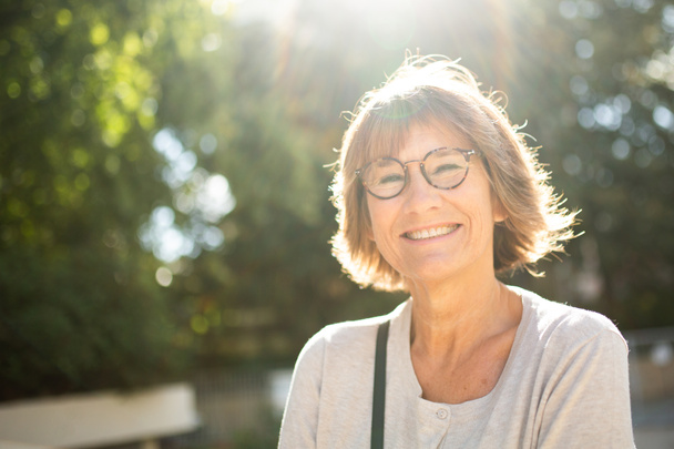 Primer plano retrato sonriendo mujer mayor fuera con gafas - Foto, imagen