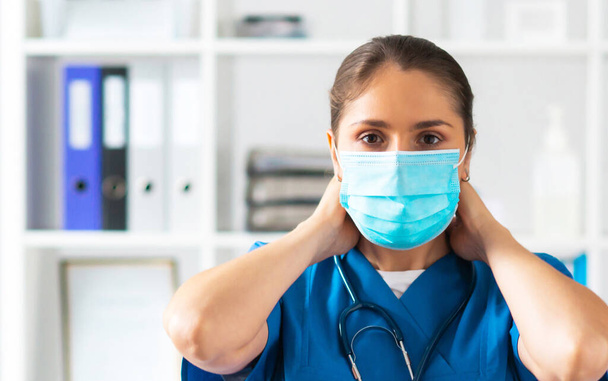 Professional medical doctor working in hospital office, Portrait of young and attractive female physician in protective mask. - Foto, afbeelding