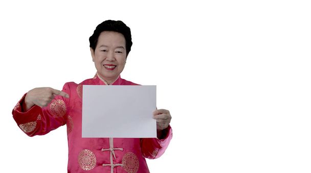 Asiatische ältere Frau im chinesischen Neujahrskostüm mit weißem Brett für fröhliche Urlaubswerbung - Foto, Bild