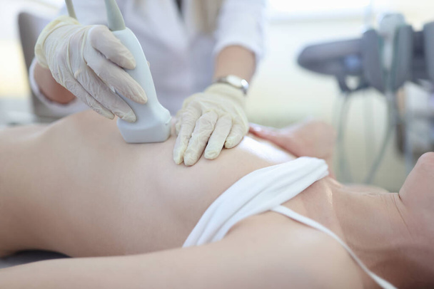Medico che tiene sonda ad ultrasuoni sul seno della paziente in primo piano clinica - Foto, immagini