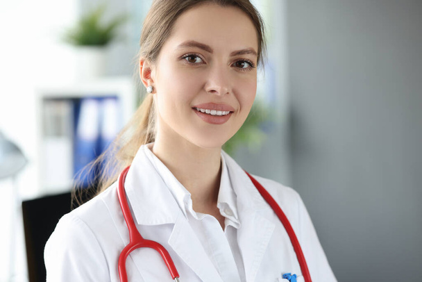Portrait of beautiful young woman medic in clinic - 写真・画像