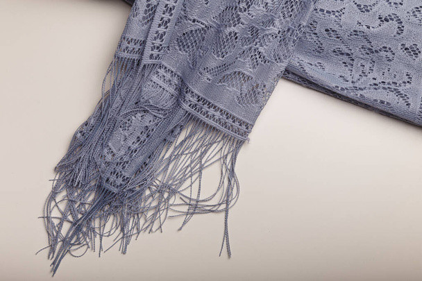 Female grey lace shawl with fringe and flowers ornaments on white table background. Clothing and accessories.  - Photo, Image